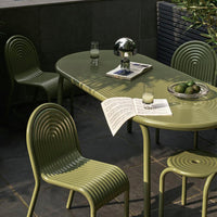 Green ribbed dining set with smooth, oval table and matching chairs, perfect for outdoor or indoor decor.