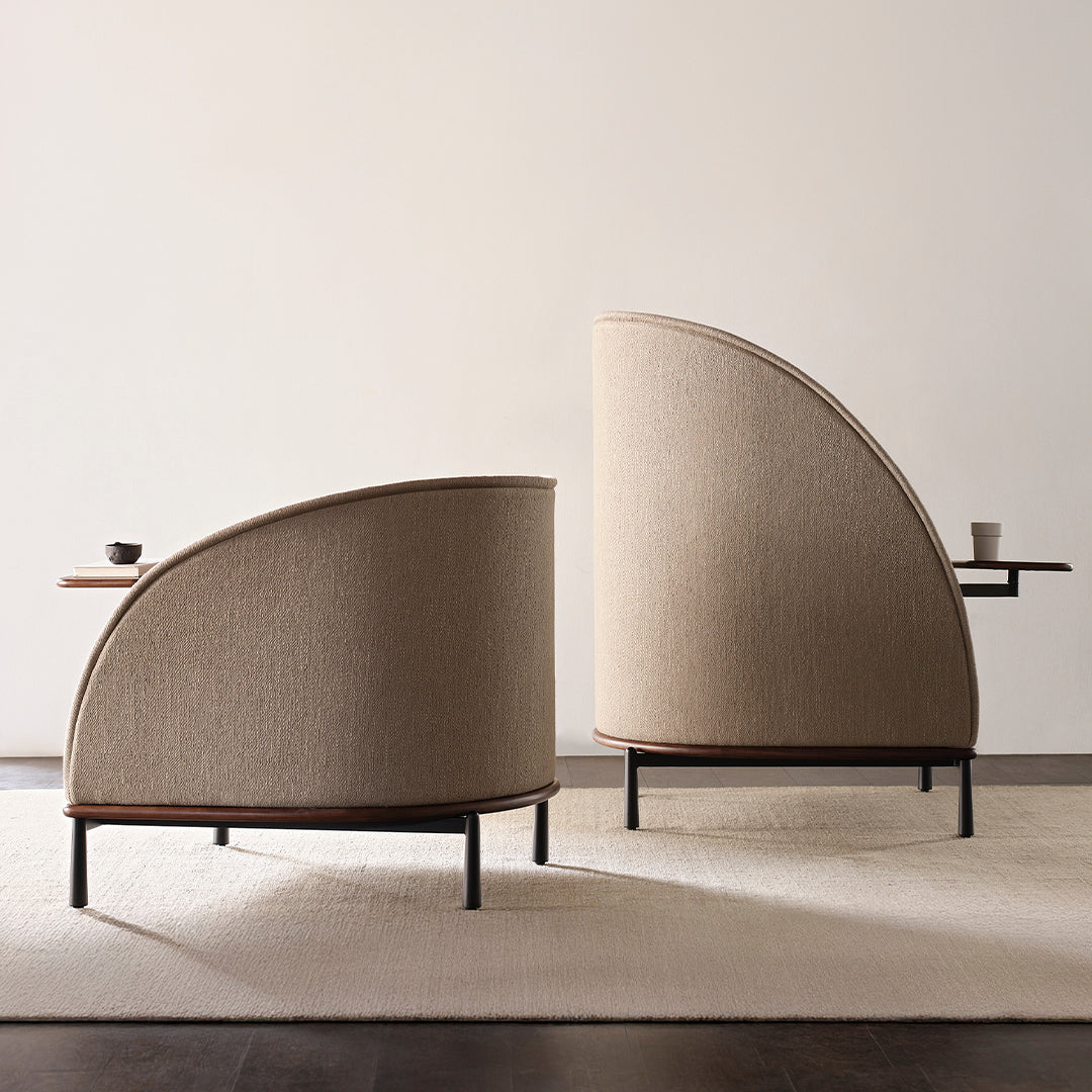 Beige upholstered chairs with curved backs and subtle texture, complemented by dark wooden accents and black metal legs.