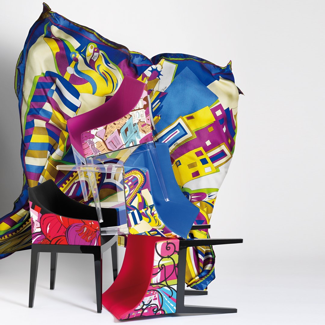 Colorful chairs in vibrant pink, blue, black, and bold graphic patterns on a striking patterned backdrop.