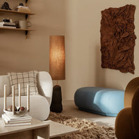 Modern interior featuring earthy brown textures, soft light beige walls, and a light blue accent piece.