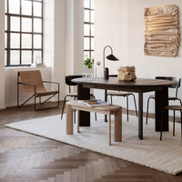 Modern living space featuring a mix of warm wood tones, neutral beige accents, and textured patterns on a soft area rug.