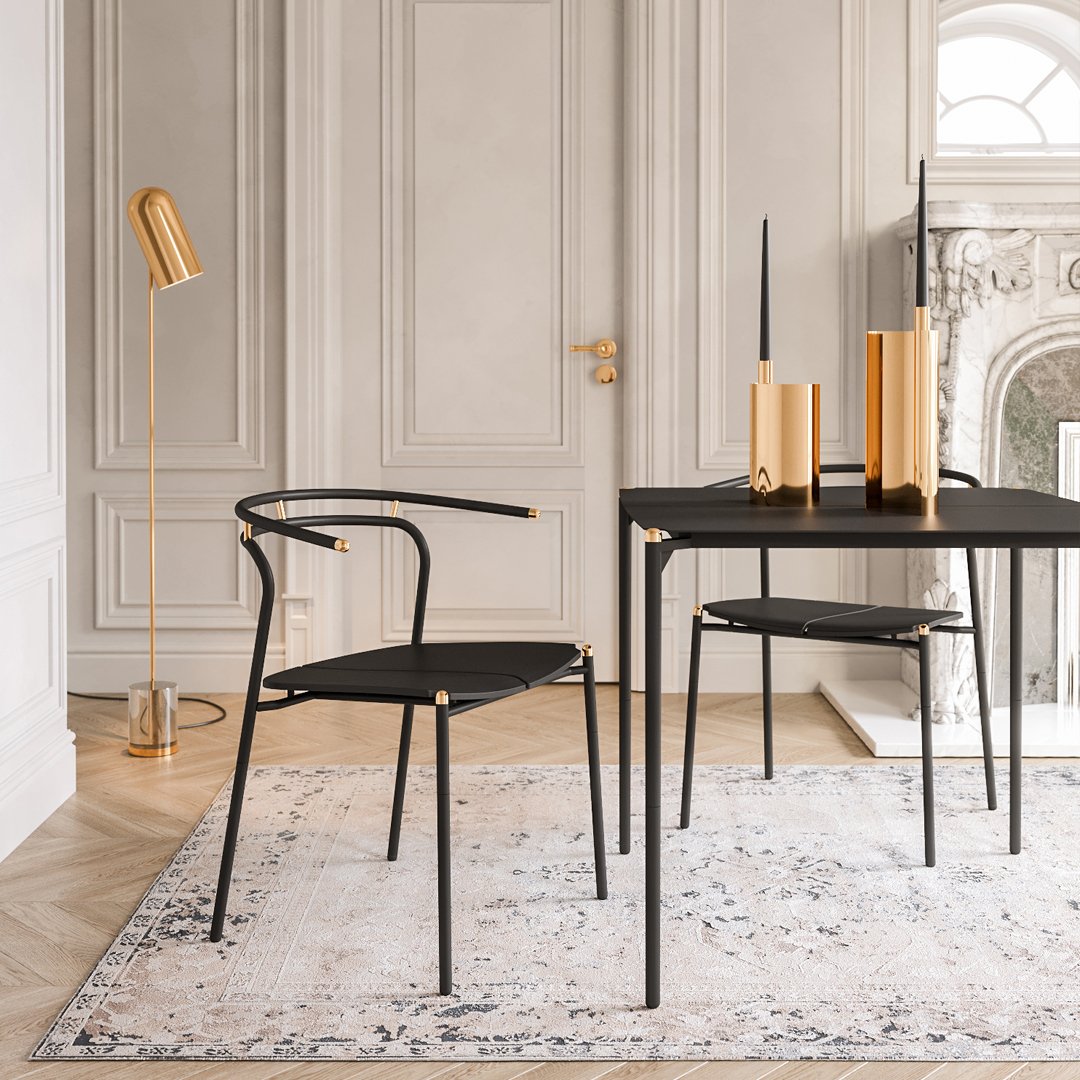 Black dining chair and table, set against a light patterned rug in a stylish, neutral-toned room with gold accents.