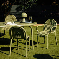 Olive green outdoor dining set with ribbed patterns, featuring a matching lamp and decorative accessories.
