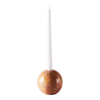 White candle atop a polished brown marble holder with natural veining, providing a modern, elegant look.