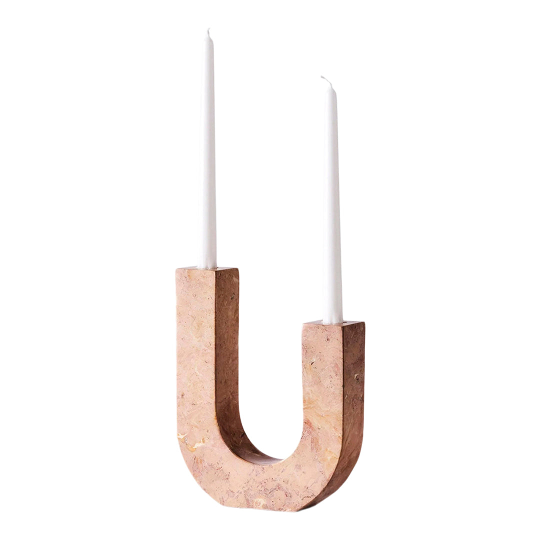 "Minimalist pink cork candle holder with two white candles, featuring sleek curves and a modern design."