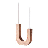 "Minimalist pink cork candle holder with two white candles, featuring sleek curves and a modern design."