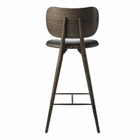 Dark wood bar stool with a smooth, curved back and a sleek black seat, featuring minimalist design elements.