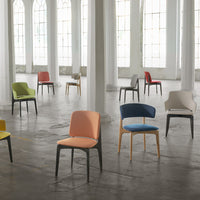 Colorful chairs in pastel and vibrant hues, featuring solid patterns, arranged in a spacious, light-filled interior.