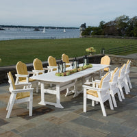"White outdoor dining set with yellow cushions, featuring a sleek, modern design against a scenic backdrop."