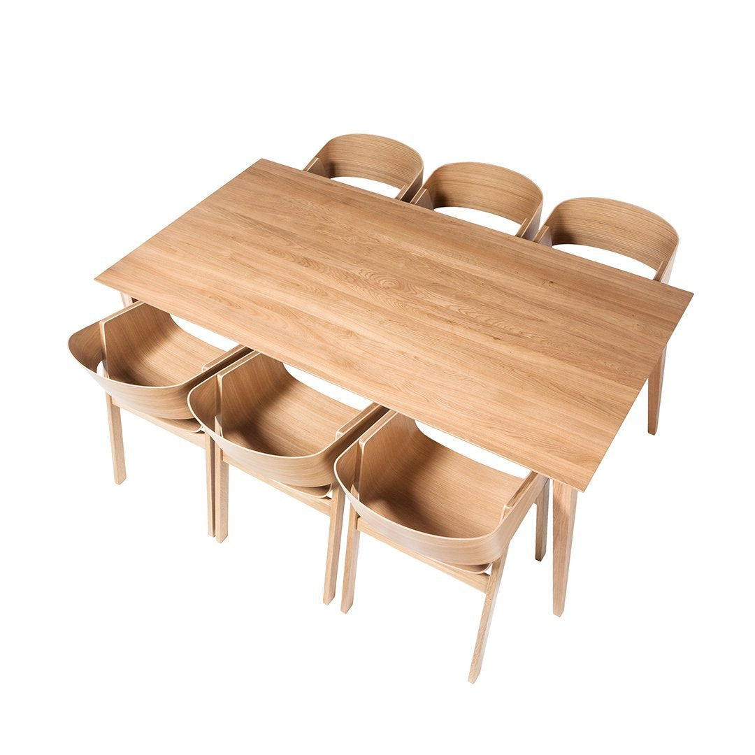 Light wood dining table with six matching curved chairs in a natural finish, showcasing a sleek, minimalist design.