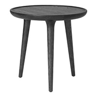 Black round side table with smooth surface and tapered legs, showcasing a sleek, minimalist design.