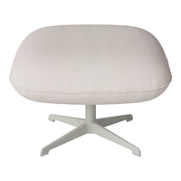 Light beige ribbed fabric ottoman with a minimalist white base, offering a modern touch to any space.
