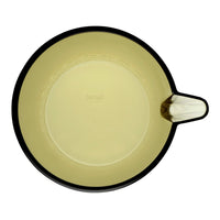 Round mixing bowl in a muted yellow with a sleek black rim and handle, featuring a smooth, glossy finish.