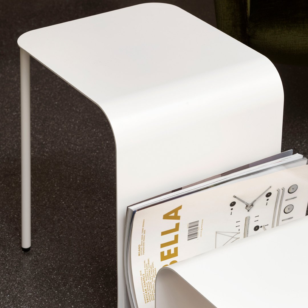 Sleek white modern side table with a minimalist design and curved form, showcasing simplicity and elegance.