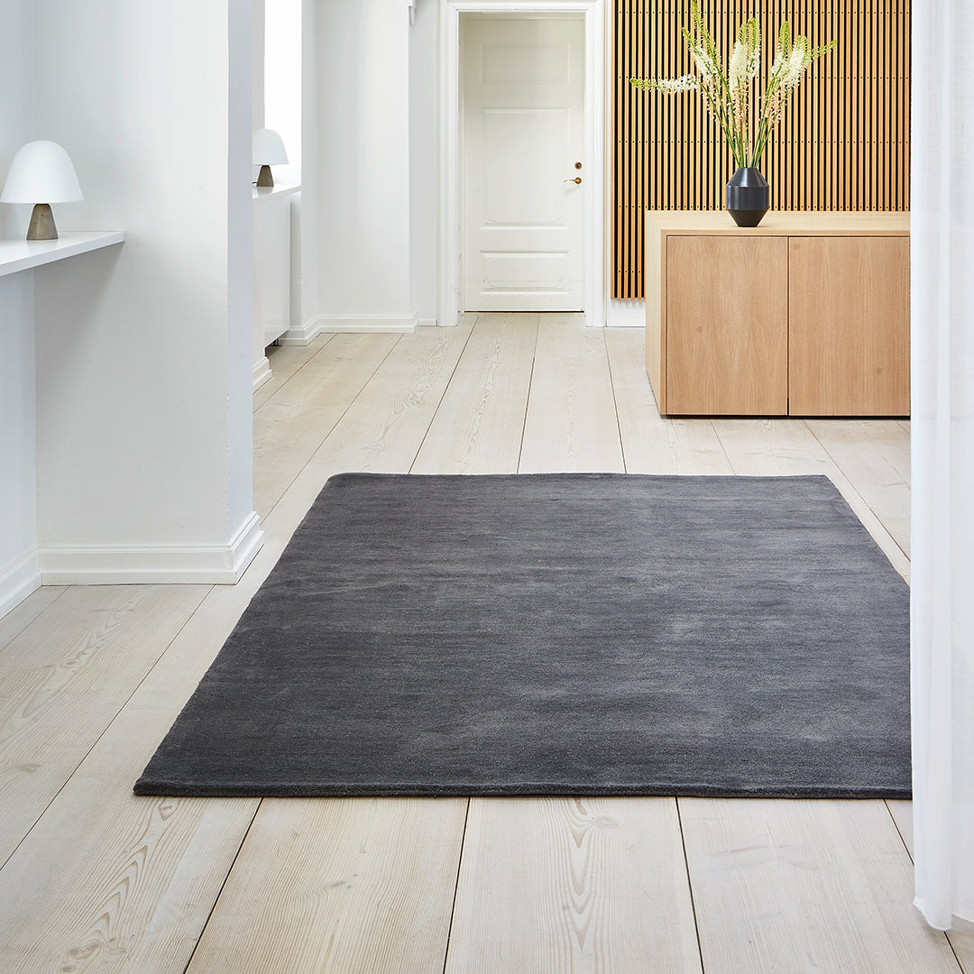 "Solid charcoal gray area rug with a textured finish, perfect for modern and minimalist interiors."