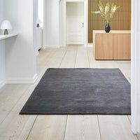 "Solid charcoal gray area rug with a textured finish, perfect for modern and minimalist interiors."
