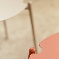 Two modern tables in soft beige and warm terracotta, featuring smooth, rounded edges and minimalist design.