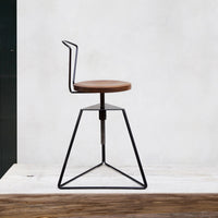 Modern black metal chair with a circular brown wood seat and geometric base, perfect for contemporary decor.