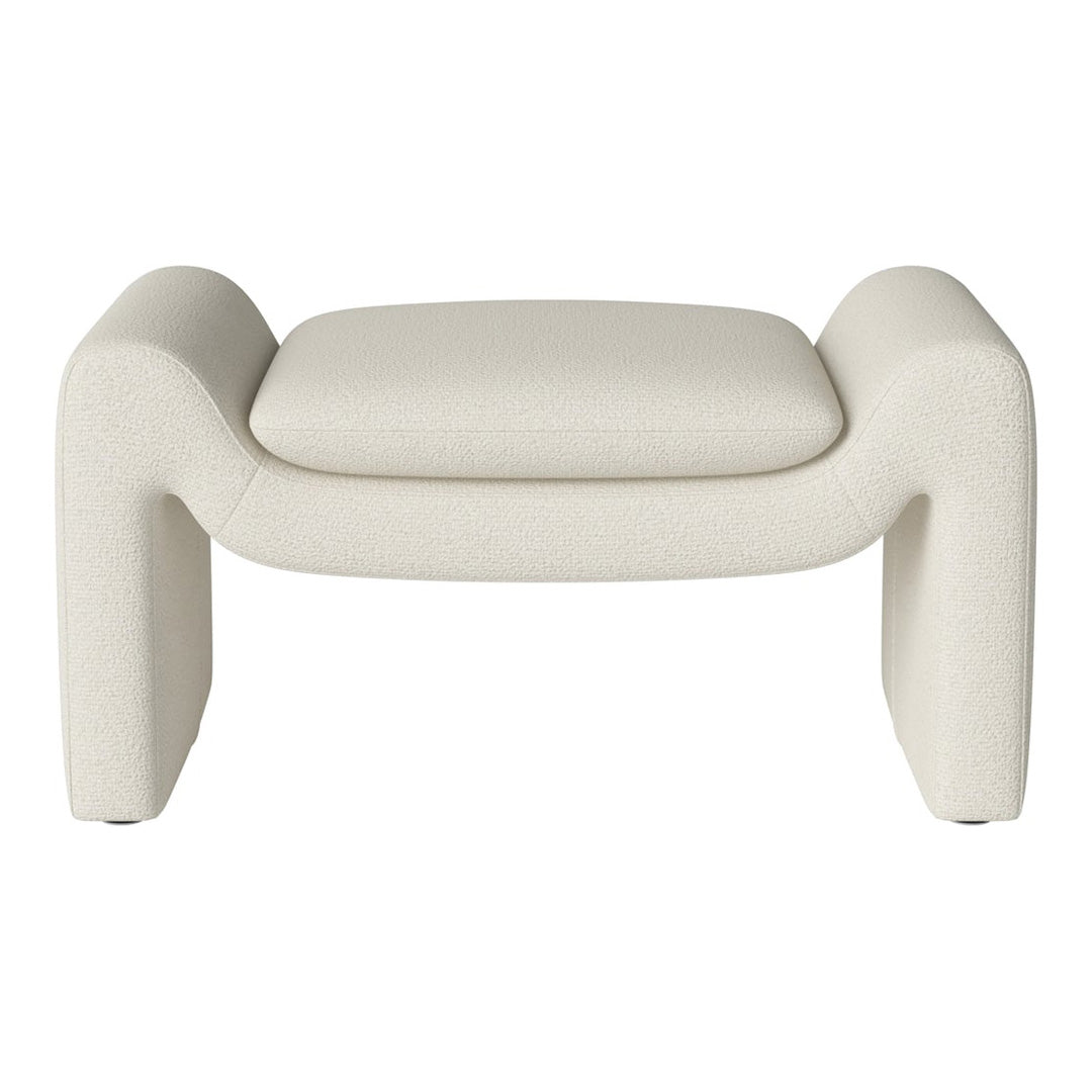 Cream-colored ottoman with a textured fabric and modern, sculptural design. Soft, minimalist aesthetic.