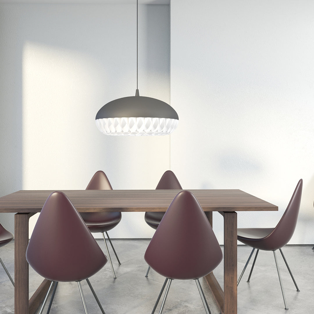 Modern pendant light in matte grey with crystal accents, paired with burgundy chairs and a sleek wooden table.