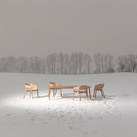 "Light wooden dining set against a snowy landscape, minimalistic design with soft natural tones and textures."
