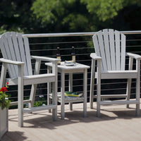Pair of white Adirondack chairs with a matching side table, set against a lush green background.