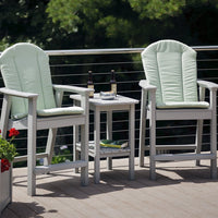 Light green cushioned patio chairs with a sleek gray frame and a matching side table on a wooden deck.