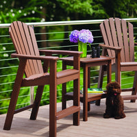 "Brown Adirondack chairs with vertical slats and a matching side table, complemented by purple flowers and green foliage."