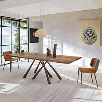 Rustic wooden dining table with a natural finish, complemented by brown leather chairs, featuring geometric patterns.