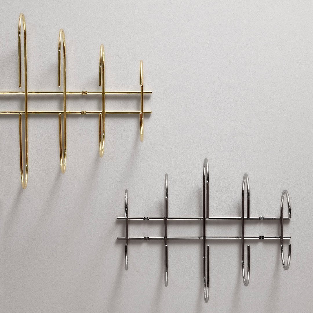 Gold and silver wall hooks in a geometric pattern, enhancing modern decor with sleek metallic finishes.