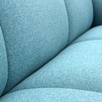 Textured light blue upholstery featuring subtle variations in hue and a smooth, inviting surface.