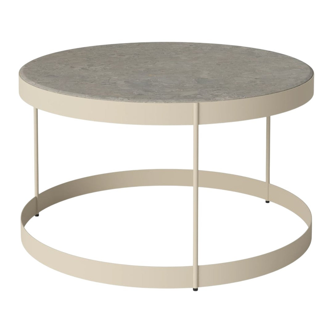 Round coffee table with a concrete top and a sleek beige metal base, perfect for modern decor.