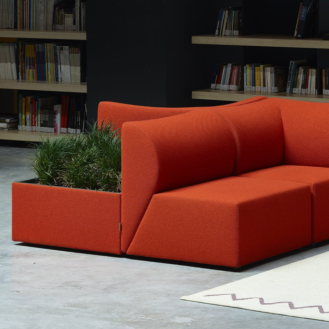 Vibrant orange modular sofa with a modern design, featuring clean lines and integrated planter.