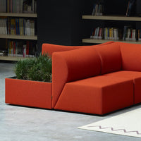 Vibrant orange modular sofa with a modern design, featuring clean lines and integrated planter.