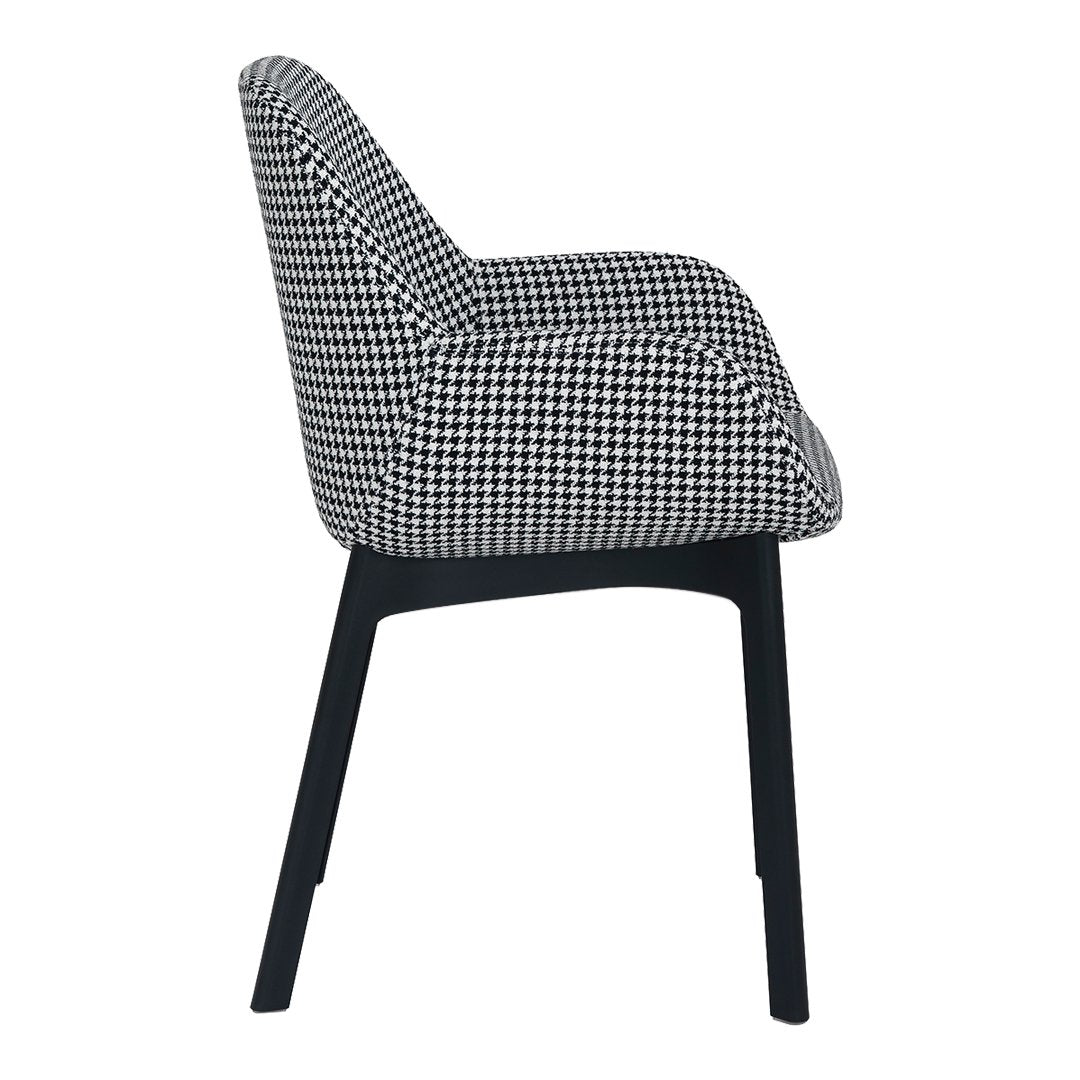 Black and white houndstooth pattern upholstered chair with sleek black legs, featured in a side view.