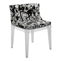 Black and white chair with heart pattern on upholstered seat and transparent legs, stylish and modern design.