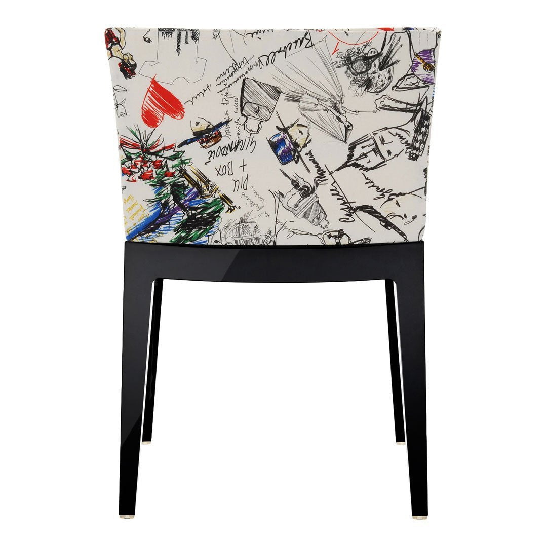 Black-legged chair with a white abstract pattern featuring colorful sketches and splashes of red and blue.