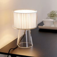 Clear glass lamp base with a white pleated shade, creating a modern and elegant lighting accent for any space.