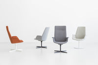 Four modern chairs in orange, light gray, dark gray, and soft beige, featuring sleek, minimalist designs.