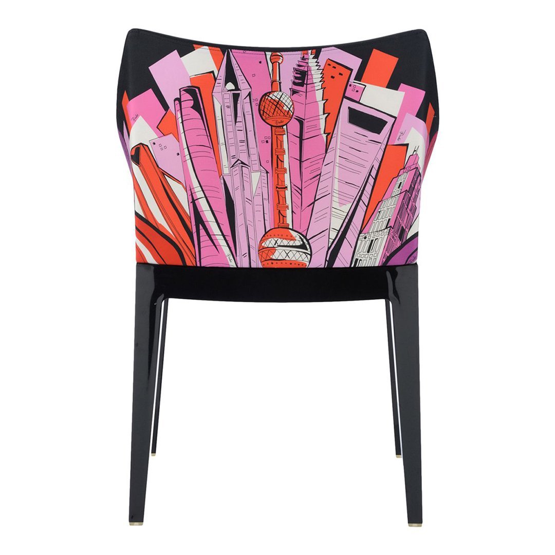 Vibrant pink and red geometric patterns on a chair with a sleek black frame. Unique modern design.