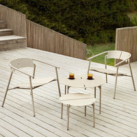 Light beige outdoor chairs and round table on a wooden deck, featuring a minimalistic design.
