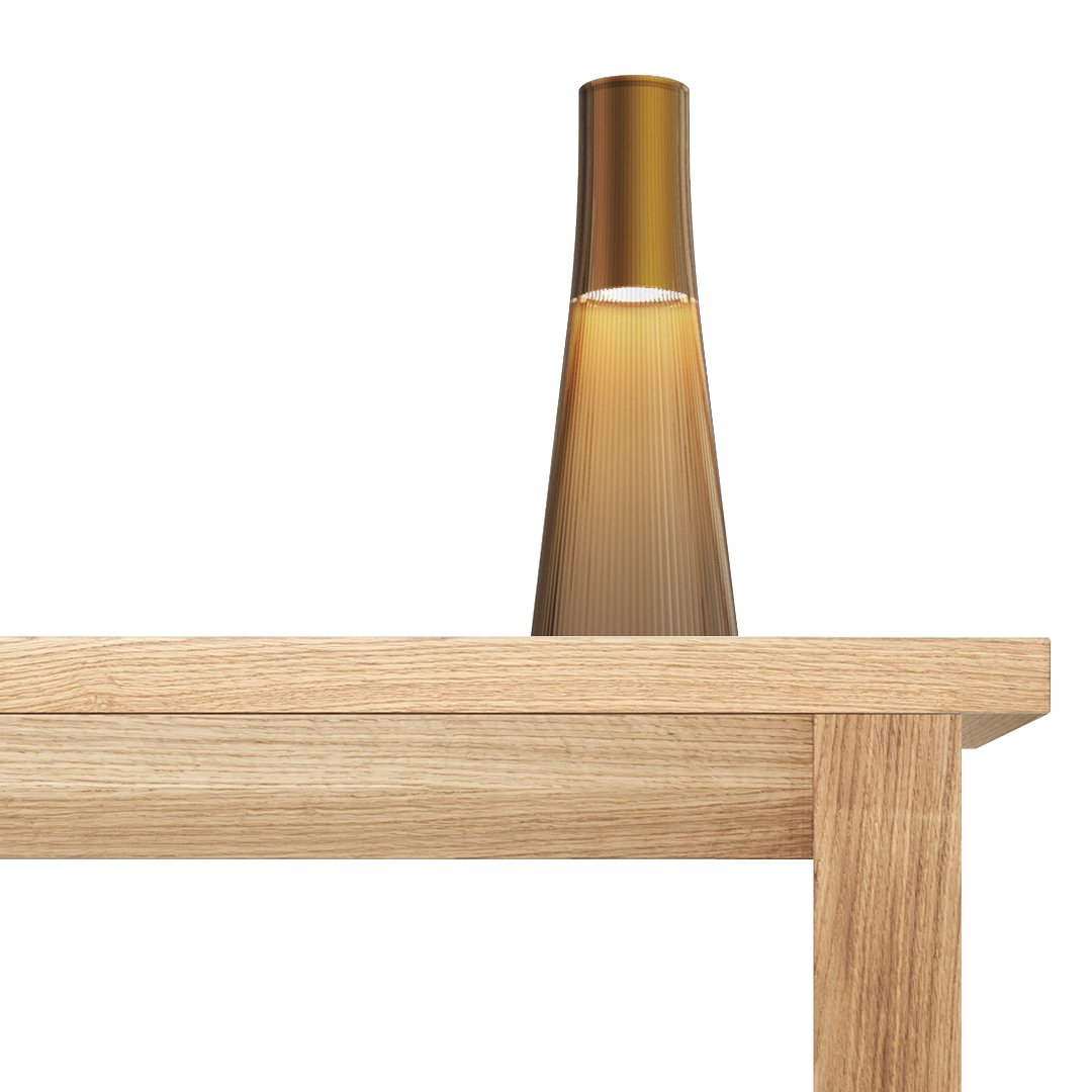 Amber glass table lamp on a natural wood surface, featuring a sleek, modern design with a soft gradient finish.
