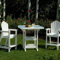 White outdoor bar set with slatted chairs and table, featuring a classic design on a lush green lawn.