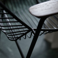 Black metal wire frame with natural wood accents, creating a modern minimalist design.