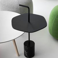 Black hexagonal tabletop with a sleek black base, featuring a modern design that complements minimalist decor.