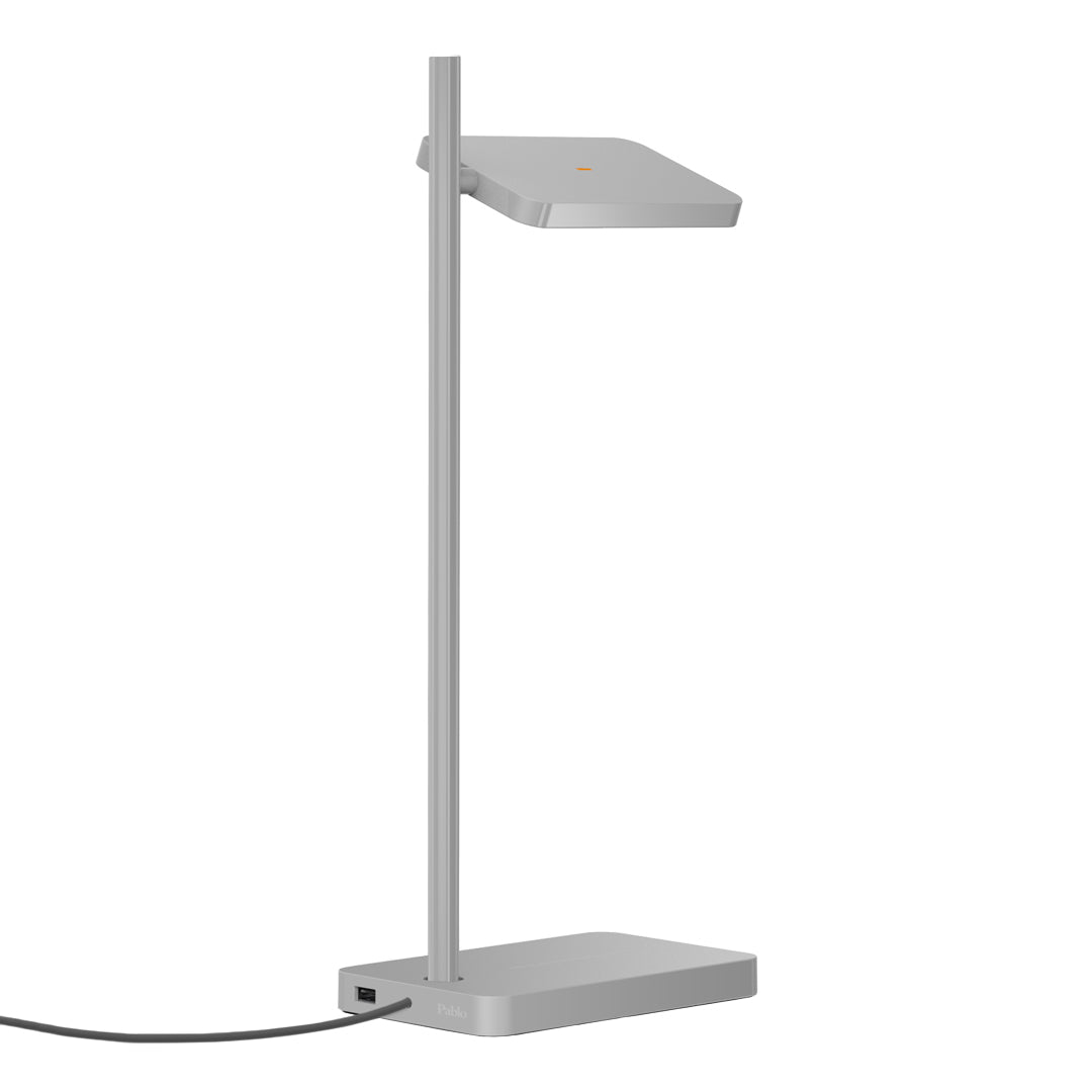 Slim silver desk lamp with a sleek geometric design and minimalistic style. Perfect for modern office spaces.