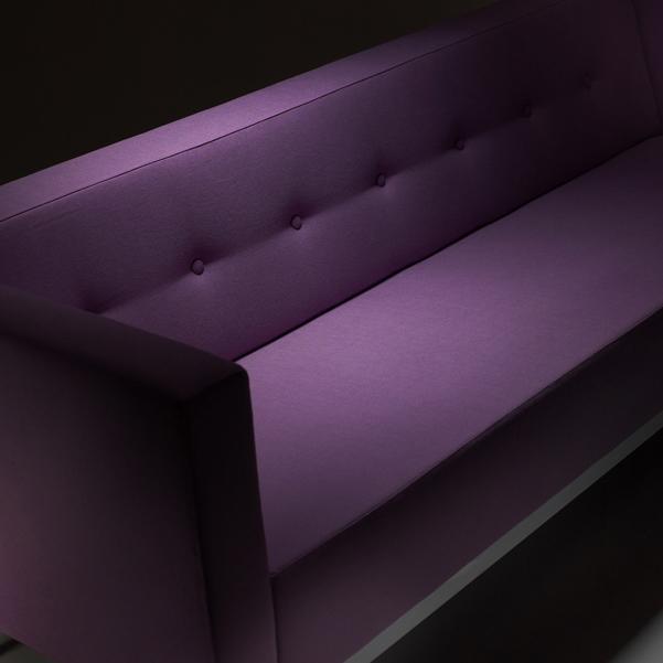 Modern purple sofa with a smooth, textured surface and elegant button-tufted detailing. Perfect for stylish interiors.