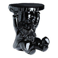 Glossy black ceramic stool with a sculptural design featuring a detailed figure supporting a round top.