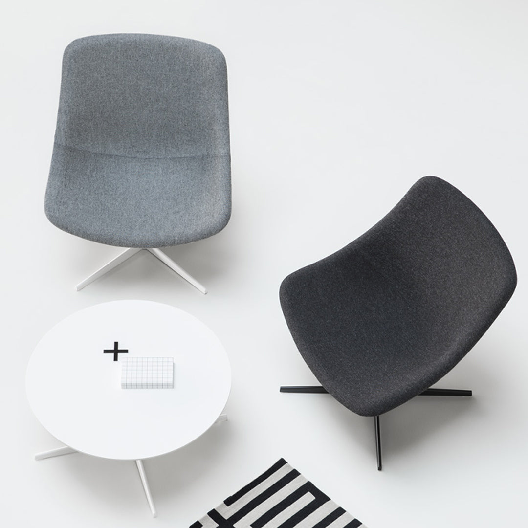 Gray and charcoal upholstered chairs paired with a sleek white table and striped black and white rug.