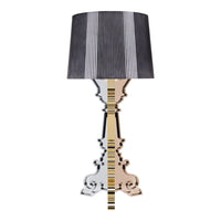 Black and white striped lampshade on a mirrored, gold-accented base with intricate patterns. Elegant and modern design.